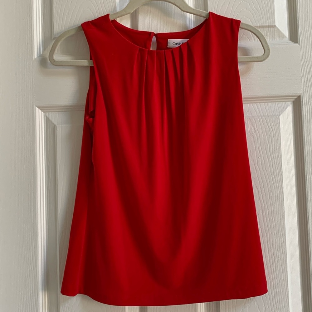 Sleeveless top. Round neck with slight gathering Single button at back.